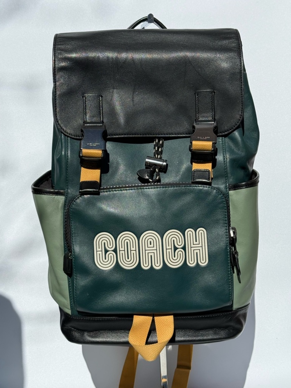 Coach Unisex Coach Track Leather Backpack Green, Black and goldenrod.